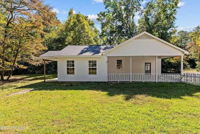 rear view of house featuring a yard