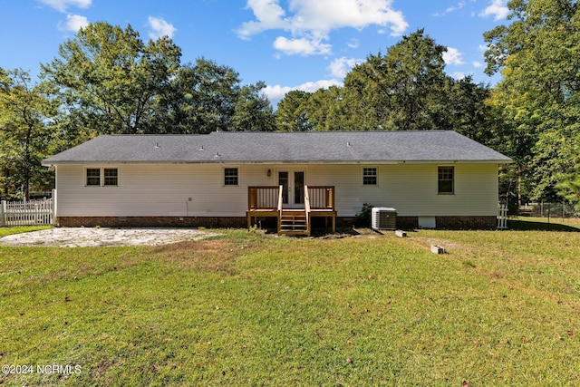 rear view of house with french doors, central AC unit, a deck, and a lawn