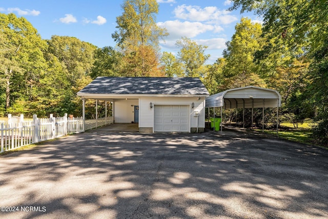 garage featuring fence and aphalt driveway