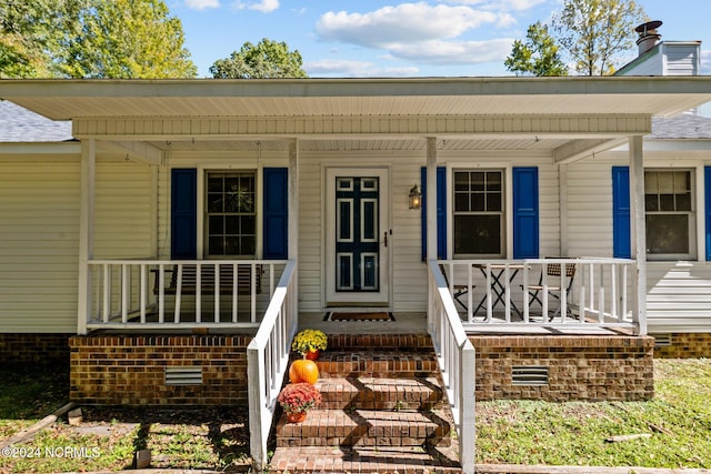 view of exterior entry with a porch