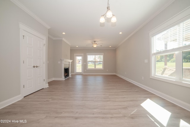 unfurnished living room featuring light wood finished floors, a fireplace, baseboards, and crown molding