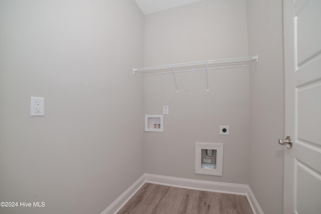 clothes washing area with hookup for a washing machine, light wood-style floors, hookup for an electric dryer, laundry area, and baseboards