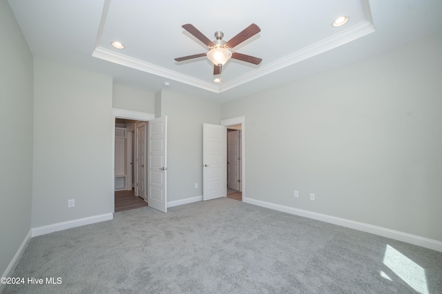 unfurnished bedroom featuring baseboards, a tray ceiling, recessed lighting, and crown molding