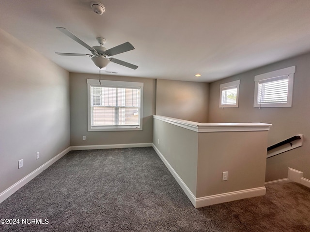 spare room featuring carpet, visible vents, baseboards, and a wealth of natural light