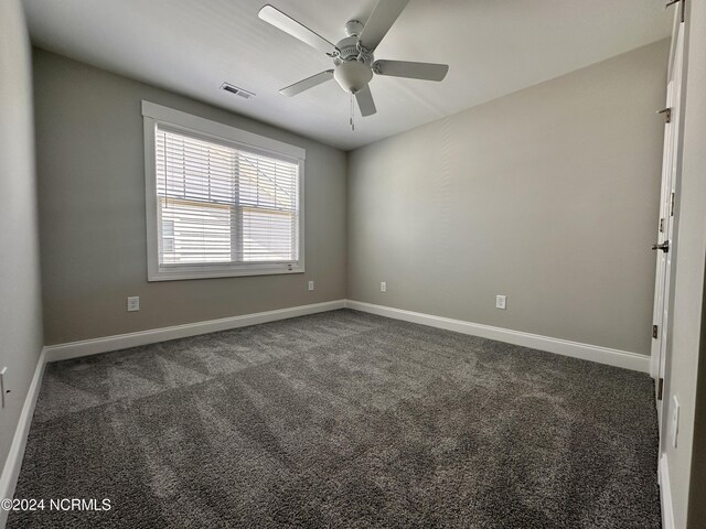 207 Eaton St, Carthage, NC 28327 - spare room with ceiling fan, dark colored carpet, and baseboards