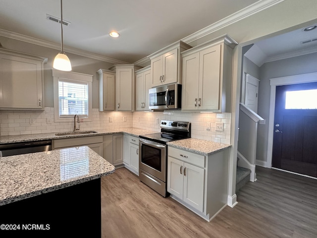 kitchen featuring appliances with stainless steel finishes, visible vents, a sink, and ornamental molding