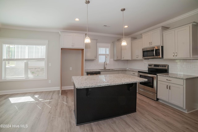 207 Eaton St, Carthage, NC 28327 - kitchen with stainless steel appliances, a sink, a center island, light wood finished floors, and crown molding