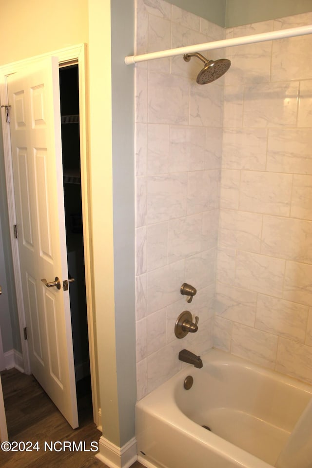 bathroom with tiled shower / bath and wood-type flooring