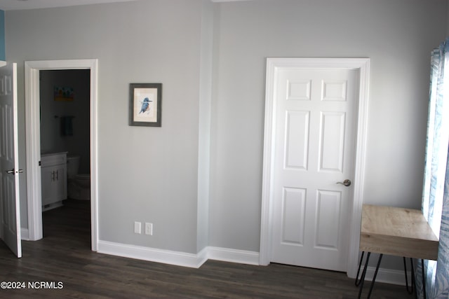 bedroom with ensuite bathroom and dark hardwood / wood-style flooring