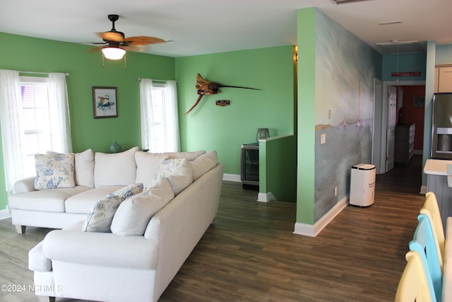 living room featuring dark wood-type flooring, a healthy amount of sunlight, and ceiling fan