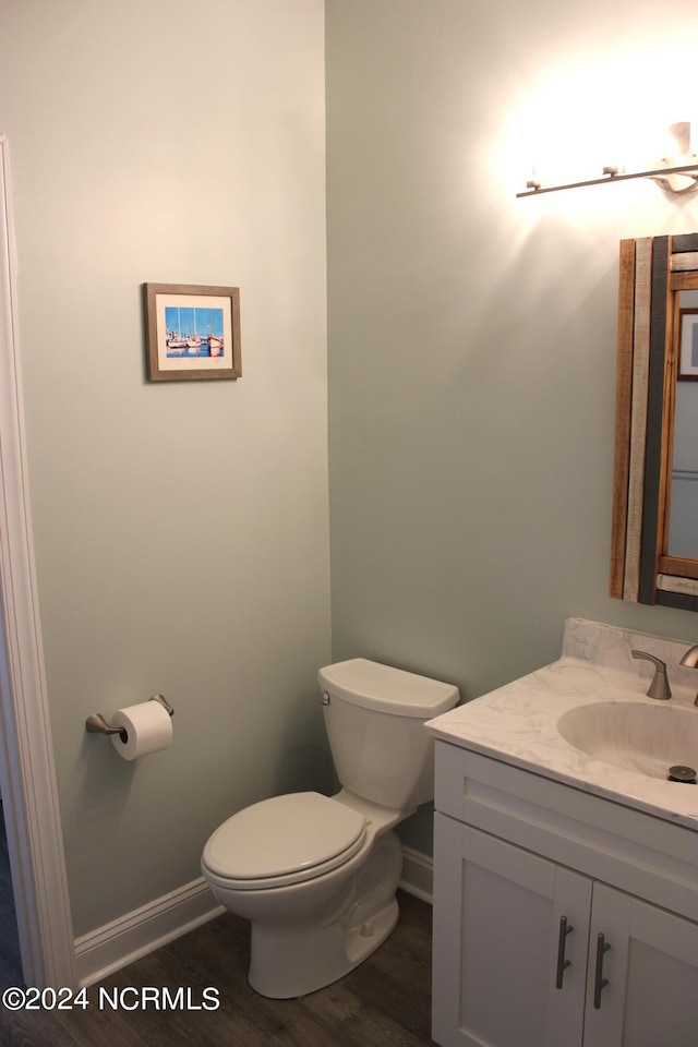 bathroom featuring vanity, wood-type flooring, and toilet