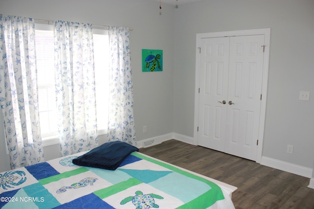 unfurnished bedroom with dark hardwood / wood-style flooring and a closet