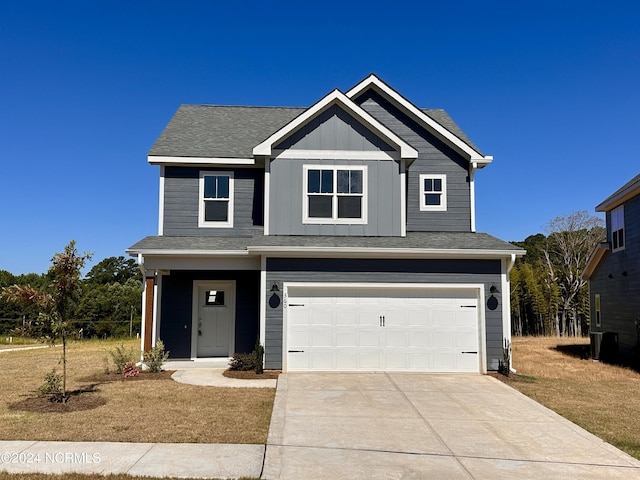 view of front facade with an attached garage, driveway, board and batten siding, and roof with shingles