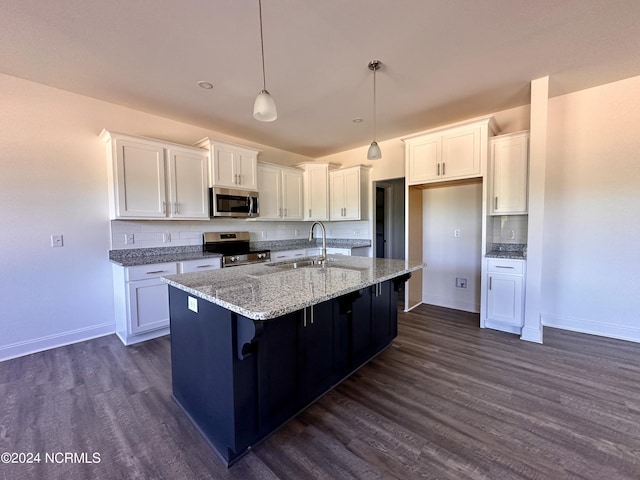 kitchen with dark wood-type flooring, a sink, white cabinets, appliances with stainless steel finishes, and an island with sink