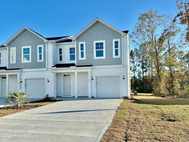 view of front of home featuring a garage, concrete driveway, and a front lawn