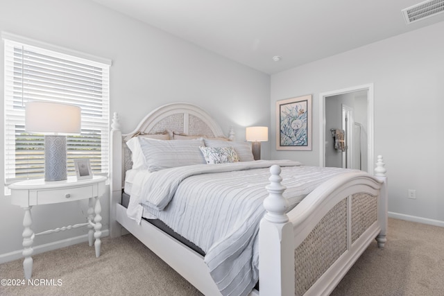 bedroom with baseboards, visible vents, and light colored carpet