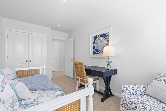 bedroom featuring baseboards, a closet, and light colored carpet