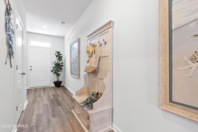 doorway to outside with baseboards, visible vents, and wood finished floors