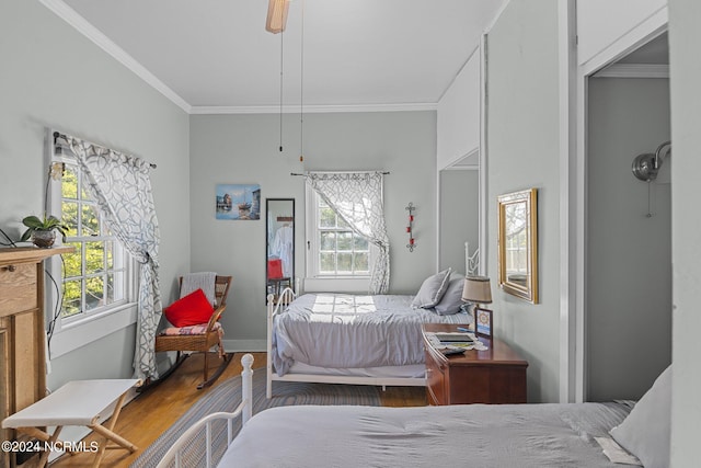 bedroom with ceiling fan, ornamental molding, hardwood / wood-style floors, and multiple windows