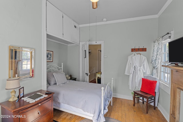 bedroom with ceiling fan, multiple windows, crown molding, and light wood-type flooring