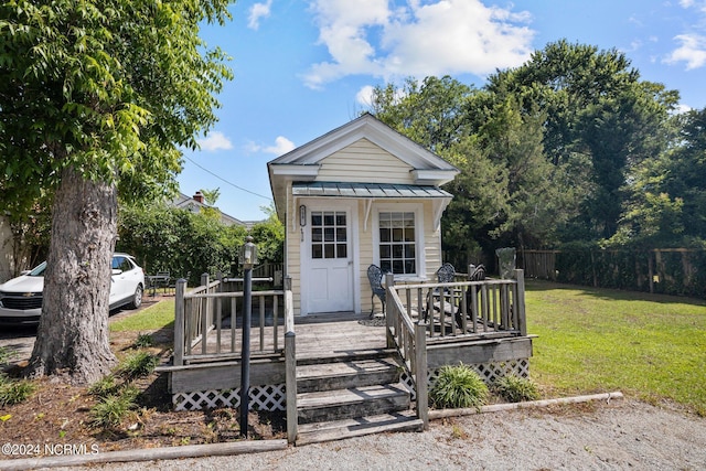 bungalow-style home featuring a front lawn and a wooden deck