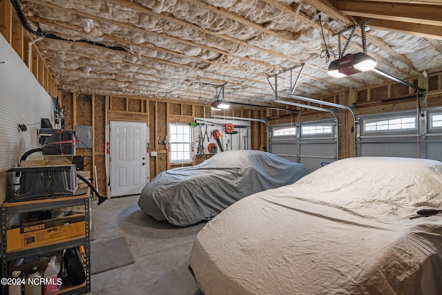 garage with a garage door opener and electric panel