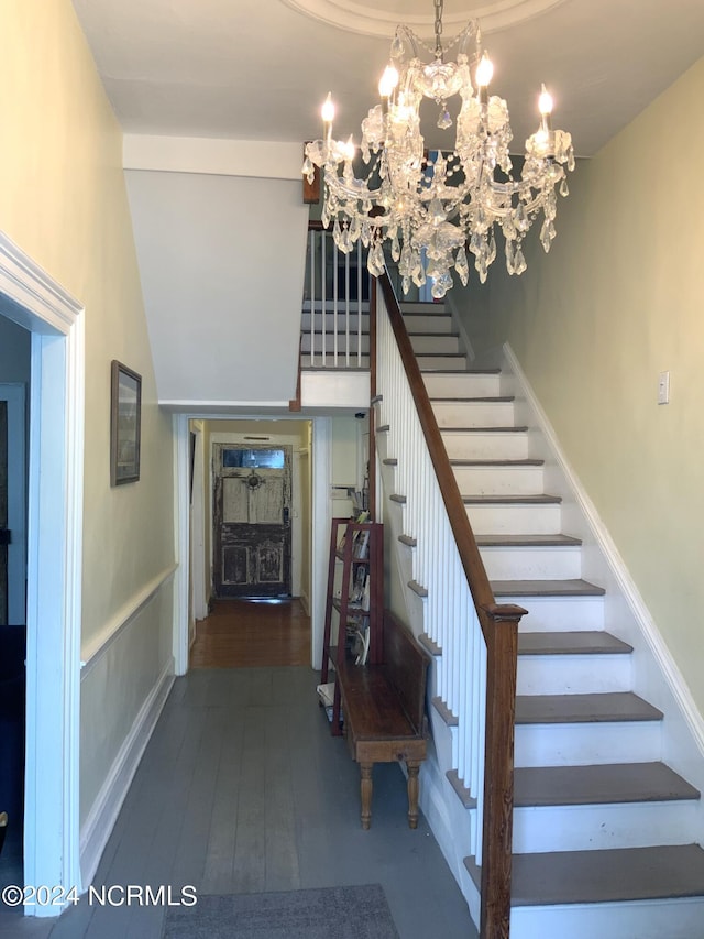 staircase with an inviting chandelier and hardwood / wood-style floors