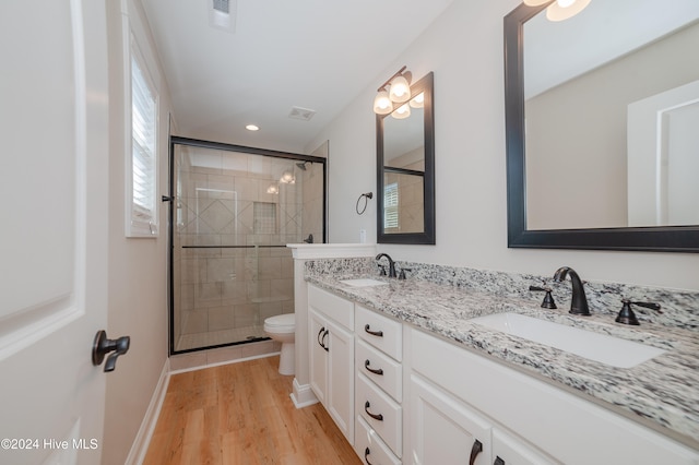 bathroom featuring walk in shower, wood-type flooring, vanity, and toilet