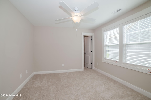 carpeted spare room with ceiling fan