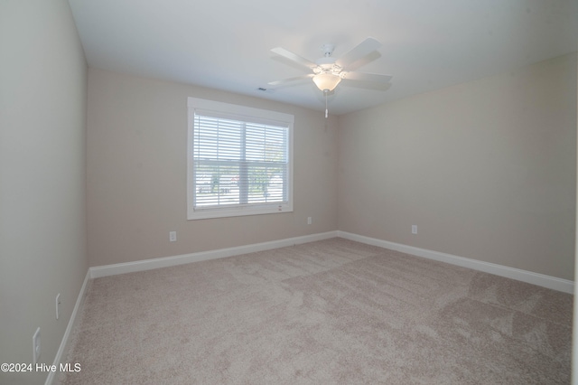 carpeted spare room with ceiling fan