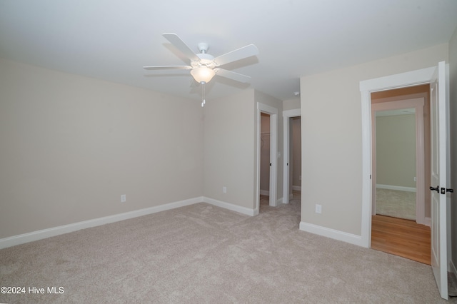 unfurnished bedroom featuring light colored carpet, ceiling fan, and a closet