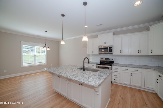 kitchen with white cabinetry, appliances with stainless steel finishes, sink, an island with sink, and light hardwood / wood-style flooring