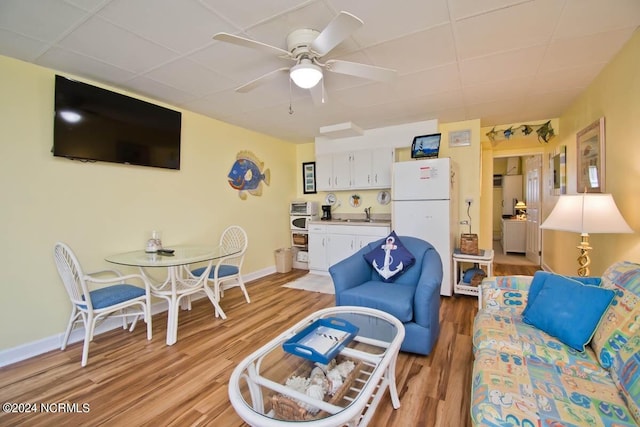 living room with light hardwood / wood-style floors, ceiling fan, and sink