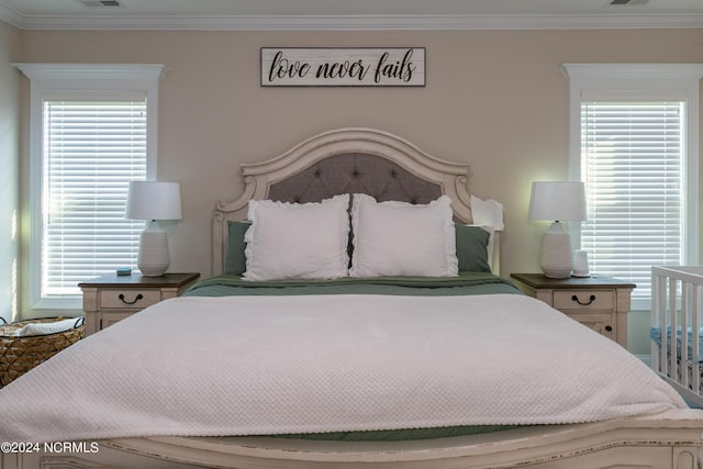 bedroom with ornamental molding and multiple windows