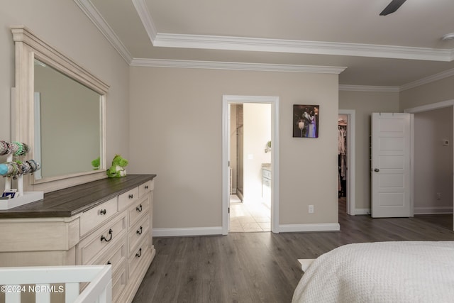 bedroom with crown molding, a walk in closet, and dark hardwood / wood-style floors