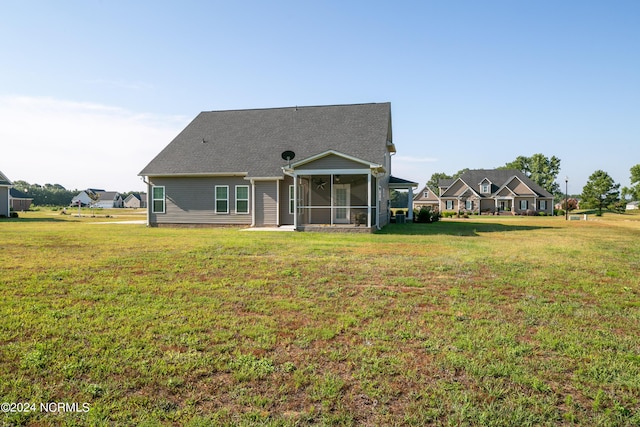 rear view of property with a sunroom and a lawn