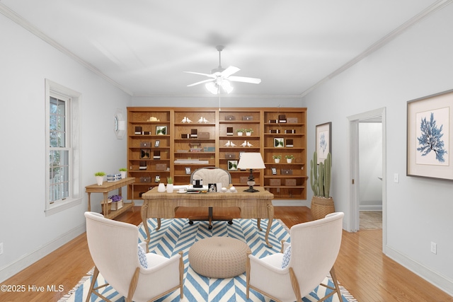 office area featuring crown molding, light wood-style floors, baseboards, and ceiling fan