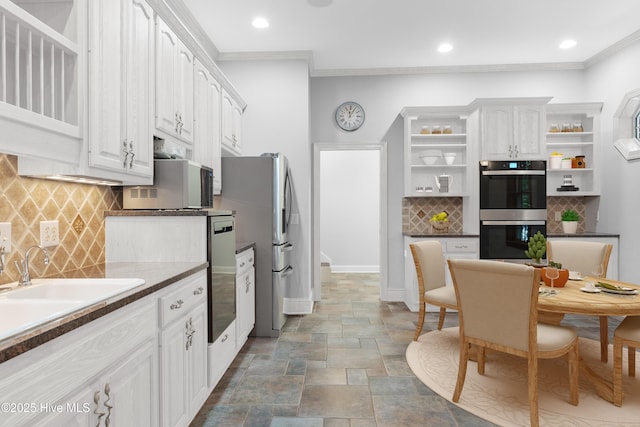 kitchen featuring stone finish floor, appliances with stainless steel finishes, ornamental molding, and open shelves