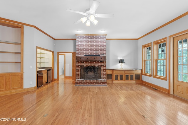 unfurnished living room with baseboards, light wood finished floors, ceiling fan, crown molding, and a brick fireplace