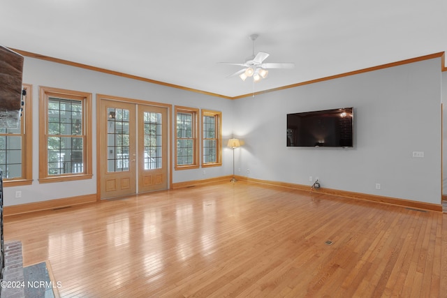 unfurnished living room with ornamental molding, a ceiling fan, french doors, light wood-style floors, and baseboards