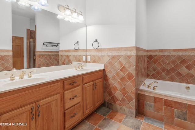 full bathroom featuring a shower stall, a bath, double vanity, and a sink