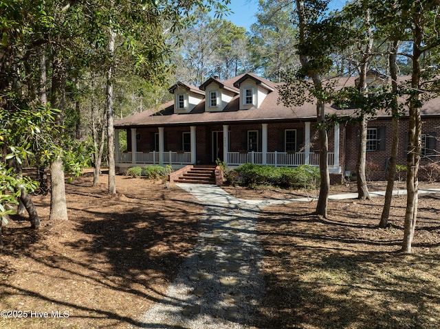 view of front of home featuring brick siding and covered porch