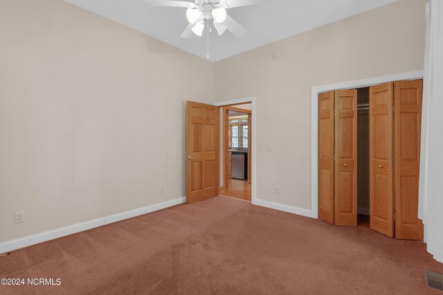 interior space featuring lofted ceiling, dark carpet, and ceiling fan