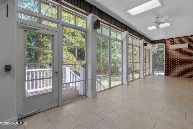 unfurnished sunroom featuring a skylight and ceiling fan