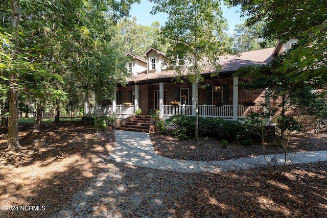 view of front facade with a porch and brick siding