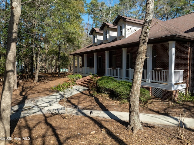 view of side of home with brick siding and a porch