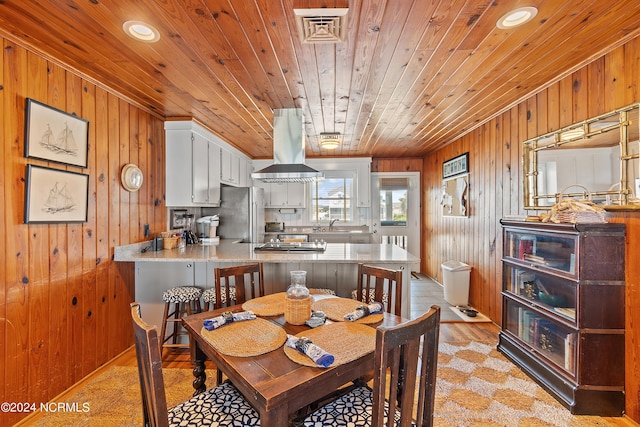 dining space with wooden walls and wooden ceiling