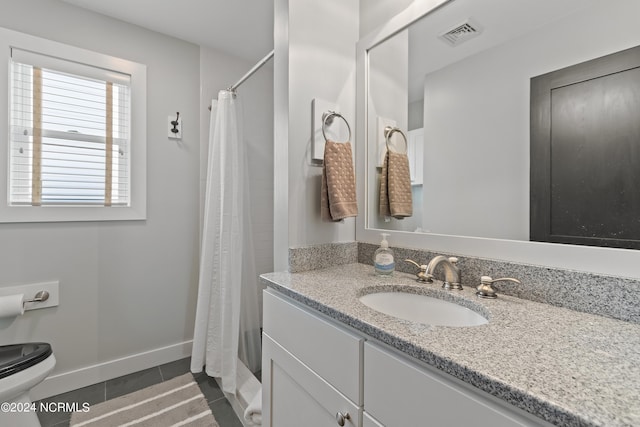 bathroom with vanity, toilet, curtained shower, and tile patterned flooring