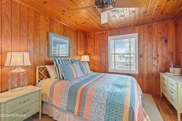 bedroom featuring wood ceiling, wood-type flooring, and wood walls