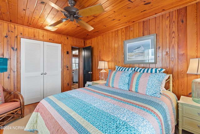 bedroom featuring wood ceiling, wooden walls, a closet, and ceiling fan